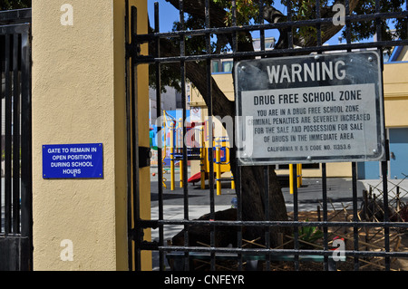 Drug Free zone scolaire signe sur terrain de jeu de l'école clôture Banque D'Images