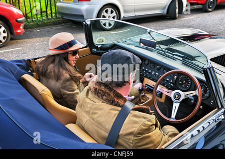Dame et gent assis dans un E-type Jaguar voiture classique, London, England, UK Banque D'Images
