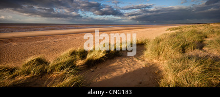 Le paramètre Octobre soleil projette une lueur chaude sur la plage et des dunes de sable à marée basse dans le lavage à Hunstanton, Norfolk, UK Banque D'Images