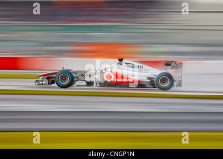 Lewis Hamilton au volant de sa McLaren MP4/26 sur un tour de parade sous la pluie au circuit de Silverstone durant la saison de F1 2011. Banque D'Images