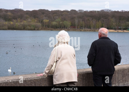 Un couple de personnes âgées donnent sur le lac à Ruislip Lido, au Royaume-Uni. Banque D'Images