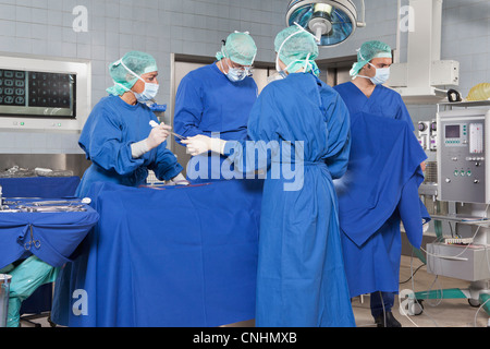 Une équipe de chirurgie sur un patient dans une salle d'opération Banque D'Images