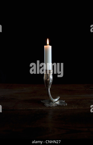 Une bougie allumée dans un chandelier d'argent titulaire Banque D'Images