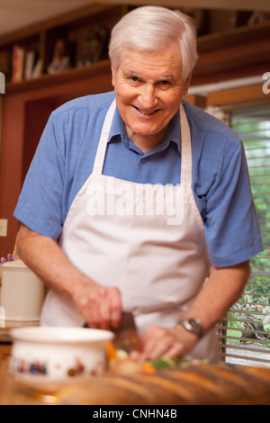 A senior man preparing food at home Banque D'Images