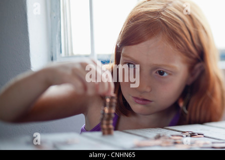 Girl stacking coins Banque D'Images