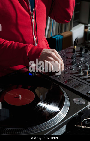 Un DJ de réglage d'un bouton sur un mélangeur de son, détail des mains Banque D'Images