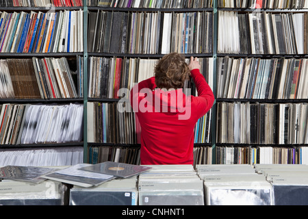 Un jeune homme la sélection d'un enregistrement à partir d'une étagère dans un magasin de disques Banque D'Images