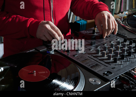 Un DJ boutons de réglage sur un sondeur mixer, détail des mains Banque D'Images