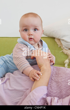 Un bambin couchée sur le ventre de la mère enceinte Banque D'Images