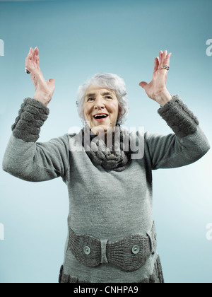 A senior woman with her arms raised in celebration Banque D'Images