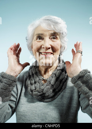 A senior woman avec son bras levés de surprise Banque D'Images