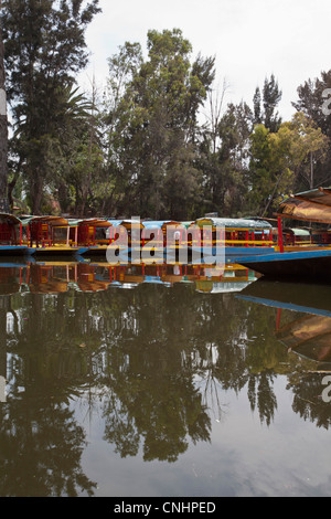 Une rangée de mouillée Trajineras, une gondole traditionnelle mexicaine type de bateau d'excursion Banque D'Images