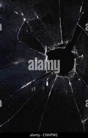 Une fenêtre avec un trou à travers le verre brisé, nuit Banque D'Images