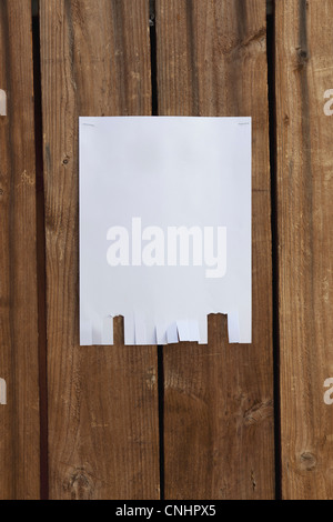 Un flyer en blanc accroché à une clôture en bois Banque D'Images
