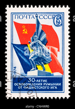 Timbre-poste de l'Union soviétique (URSS) illustrant une statue d'un soldat et les drapeaux de la Roumanie et l'Union soviétique. Banque D'Images