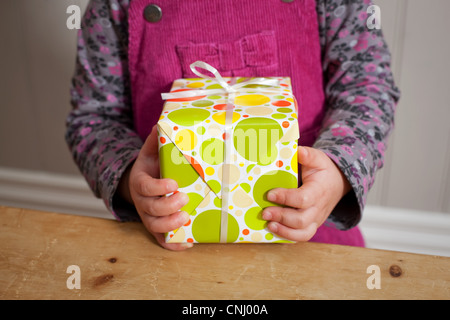 Little girl holding a gift Banque D'Images