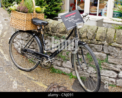 Livraison à l'ancienne location avec panier en osier à l'arrière garée devant la vitrine de Derbyshire en Angleterre Banque D'Images