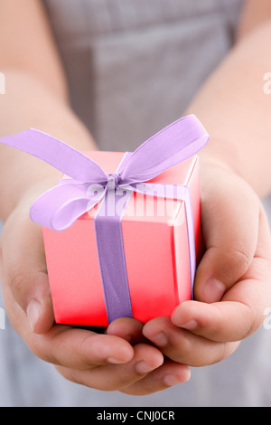 Girl holding a small gift Banque D'Images