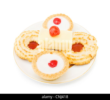 Biscuits à la noix de coco et confiture avec tranche de gâteau et cerise sur le dessus. Plus isolé sur fond blanc. Banque D'Images