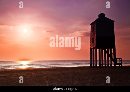 Un contre jour tourné contre la lumière de l'inhabituelle phare sur pilotis à Burnham-on-Sea, Somerset, England, UK, au coucher du soleil. Banque D'Images