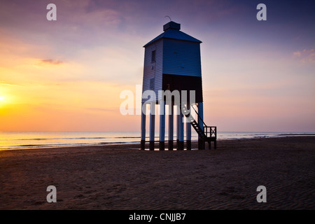 Coucher de soleil sur le phare inhabituelle sur pilotis à Burnham-on-Sea, Somerset, England, UK, avec canal de Bristol au-delà. Banque D'Images