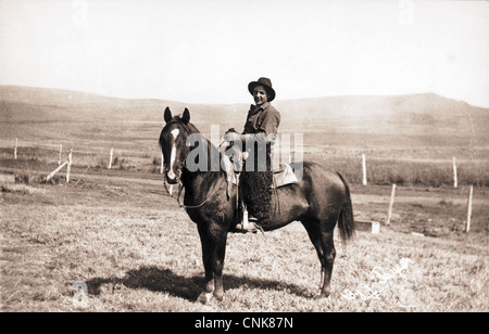 Petit Cowboy à cheval dans un champ Banque D'Images