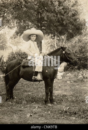 Beau petit garçon en paille géante équitation poney Banque D'Images