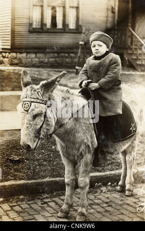 Petit garçon dans un manteau d'hiver équitation poney Banque D'Images