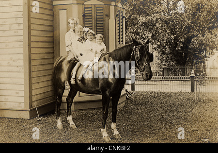 Quatre enfants, un cheval à la maison Banque D'Images