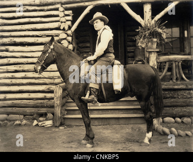 Cowboy à cheval à Log Cabin Banque D'Images