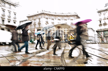 Motion intentionnellement floue image abstraite des navetteurs dans une ville européenne en un jour de pluie. Tourné en Milan, Italie Banque D'Images