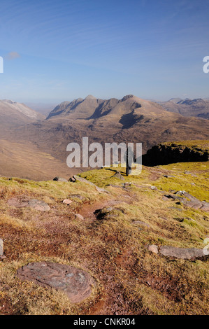 Walker sur le sommet de Tom Gruagaich, Beinn Alligin na, Torridon, avec Liathach dans l'arrière-plan Banque D'Images