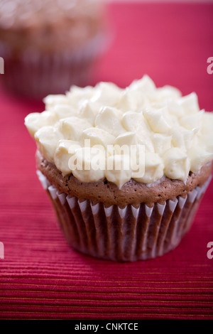 Délicieux cupcake chocolat avec glaçage à la vanille sur un napperon rouge -l'accent peu profondes Banque D'Images