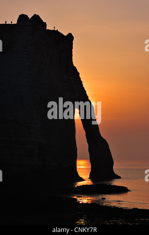 Silhouette de la Porte d'Aval, une arche naturelle dans les falaises de craie d'Etretat au coucher du soleil, la Côte d'Albâtre, Haute-Normandie, France Banque D'Images