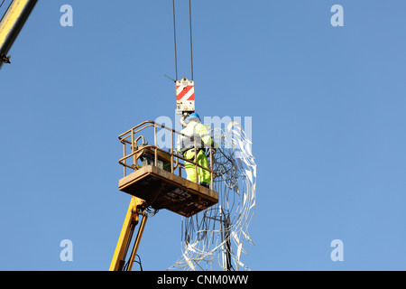 Ouvrier à l'aide d'une grue et d'un palan pour enlever les lumières de Noël et décorations, UK Banque D'Images