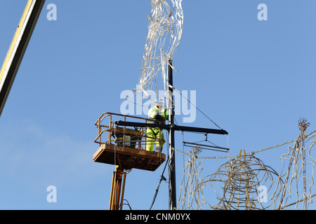 Ouvrier à l'aide d'une grue et d'un palan pour enlever les lumières de Noël et décorations, UK Banque D'Images