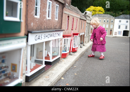 Une petite fille se promène dans les rues de Wimborne Model Village à Paris Banque D'Images