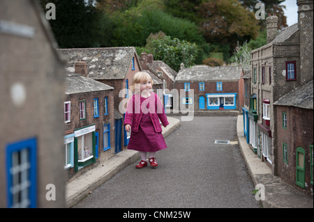 Une petite fille se promène dans les rues de Wimborne Model Village à Paris Banque D'Images