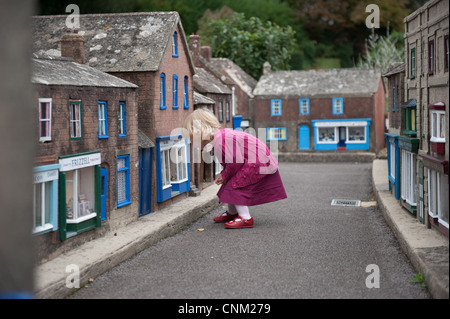 Une petite fille se promène dans les rues de Wimborne Model Village à Paris Banque D'Images