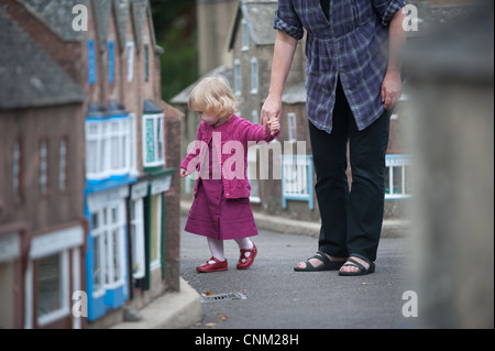 Une petite fille se promène dans les rues de Wimborne Model Village à Paris Banque D'Images