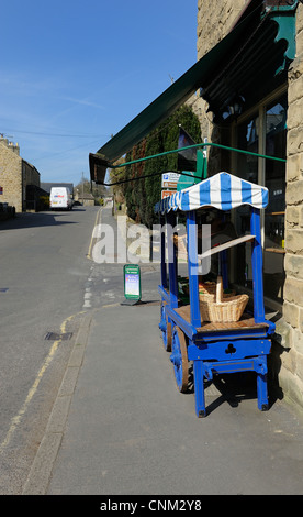 Petit chariot de marché en dehors d'un corner shop dans eyam derbyshire england uk Banque D'Images