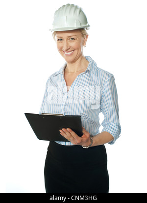 Female architect posing in front of camera wearing hardhat Banque D'Images