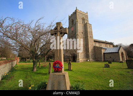 L'église de Saint Mary's à Brancaster avec une couronne de coquelicots sur un monument de guerre à la 1ère guerre mondiale. Banque D'Images