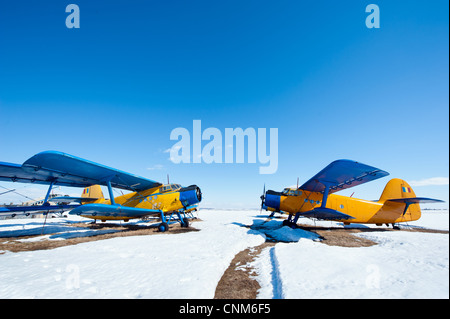 Des avions en stationnement sur une prairie avec de la neige dans une journée ensoleillée Banque D'Images