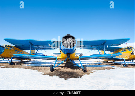 Des avions en stationnement sur une prairie avec de la neige dans une journée ensoleillée Banque D'Images