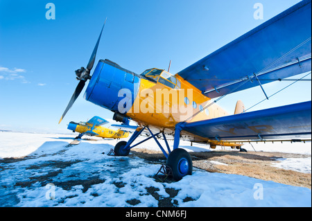 Des avions en stationnement sur une prairie avec de la neige dans une journée ensoleillée Banque D'Images