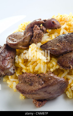 Foie de poulet cru avec oignons et riz au curry sur une plaque Banque D'Images