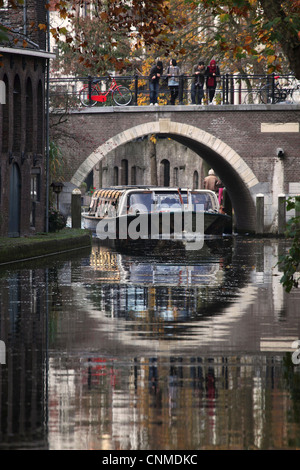 Une barge de visites sous un pont sur l'Oudegracht Canal dans la ville néerlandaise d'Utrecht, Utrecht, Pays-Bas, Europe Province Banque D'Images