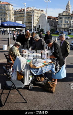 Une foule de gens à l'un des étals de poissons frais au marché du poisson frais tous les jours sur le vieux port de Marseille, France Banque D'Images