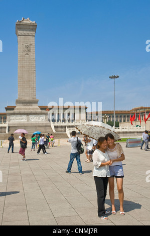 Les touristes chinois de la Place Tiananmen, la prise de photographies de l'autre avec le monument aux héros du peuple et le grand Hal Banque D'Images